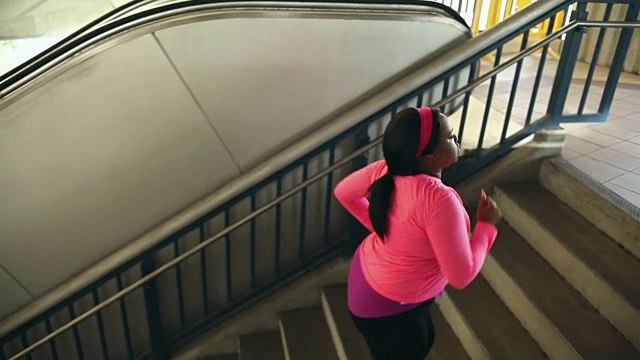 黑人妇女在城市里锻炼，走上楼梯视频素材
