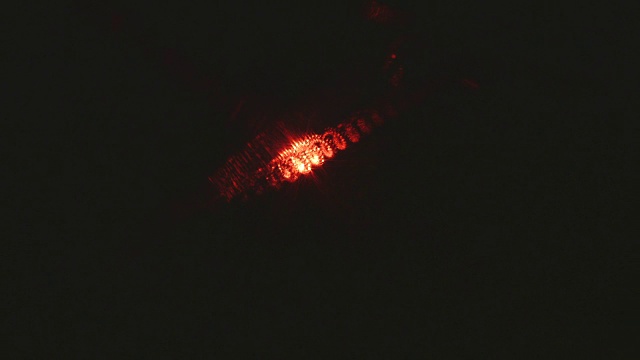 闪烁的红色激光散射的特写，同时通过一个模糊的线圈。视频素材
