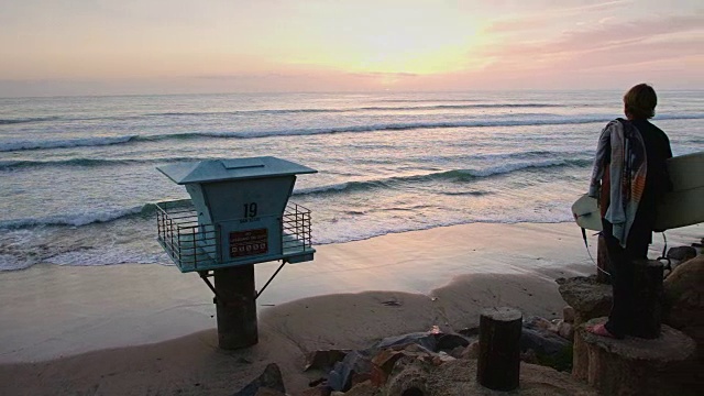 平盘拍摄的冲浪者望向海洋在日落视频下载