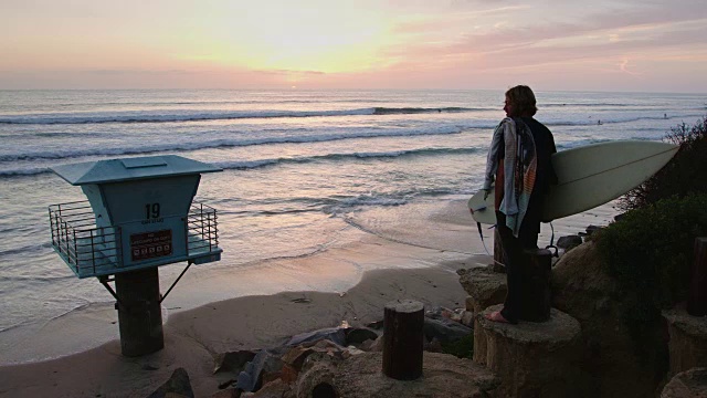 冲浪者在日落时观看海洋视频素材