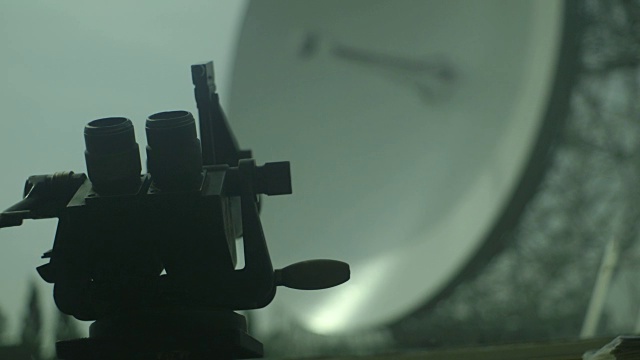 手持POV镜头在前景中对焦双筒望远镜前面失去焦点的约德瑞尔银行天文台无线电碟在背景，柴郡，英国。视频素材