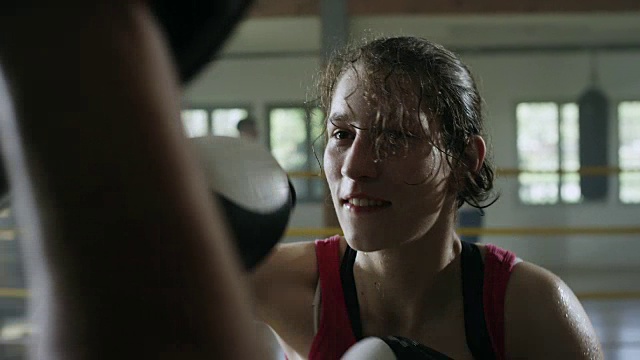 成功的女拳击手在健身房里戴拳击手套视频素材