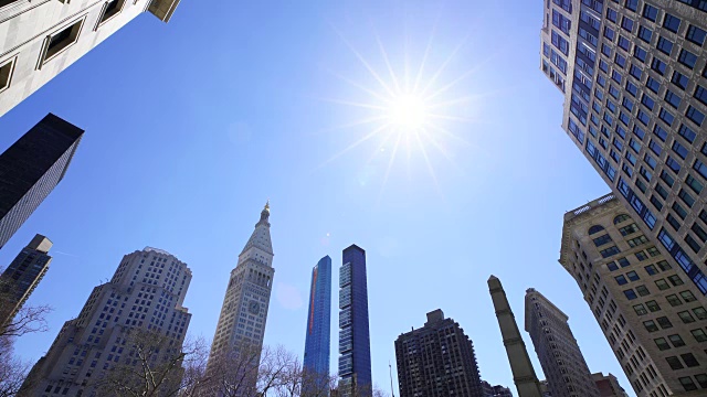 在纽约市熨斗区，新的高层住宅楼在曼哈顿中城的天际线上建造起来。阳光照耀着麦迪逊广场公园和建筑物。视频下载