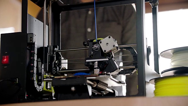 铜。创意工程师与安全眼镜倾斜在现代设计工作室的3D打印机。视频素材