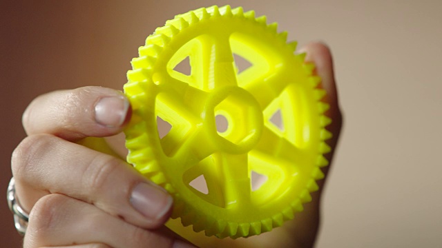 ECU。手持亮黄色齿轮创建与3D打印技术。视频素材