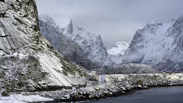 挪威罗浮敦岛海边的雪山，有拖车在路上行驶的4K镜头视频下载