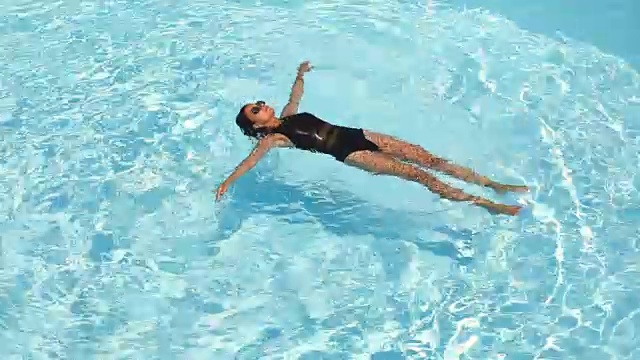 一个年轻女子在游泳池里游泳视频下载