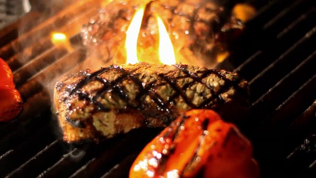 牛排被放在炙热的烤架上。视频下载