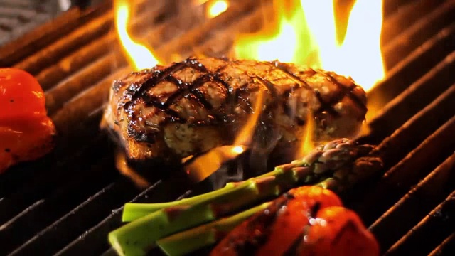牛排被放在炙热的烤架上。视频下载