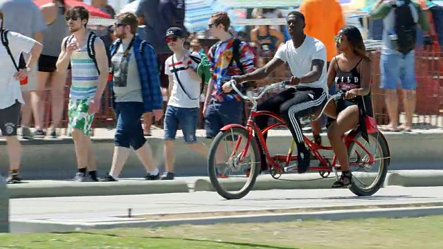 加州健康的生活方式，人们步行和骑自行车在圣塔莫尼卡海滩在洛杉矶，加州，4K，从RAW文件视频素材