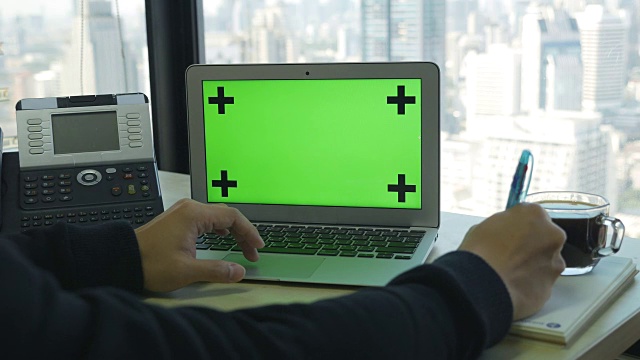 使用绿色电脑屏幕和高层办公背景视频素材