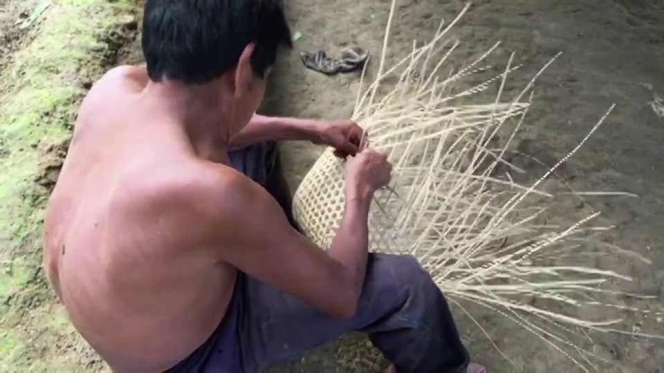 在厄瓜多尔亚马逊的土著萨拉亚库自治区，一名中年印度基奇瓦族男子正在编织一个天然的植物篮子视频素材