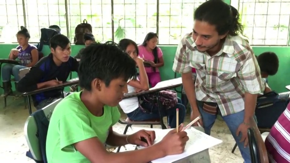 在萨拉亚库的土著自治地区，年轻的混血儿或混血厄瓜多尔教师在期末考试中指导基奇瓦族印度学生的广角镜头。视频素材