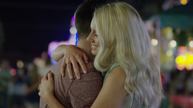 近距离慢动作拍摄的夫妇拥抱在游乐园在晚上/愉快的Grove，美国犹他州视频下载