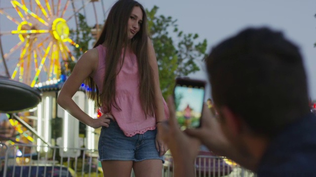 中等平移拍摄的男人拍摄女人在游乐园/愉快的格罗夫，犹他州，美国视频下载