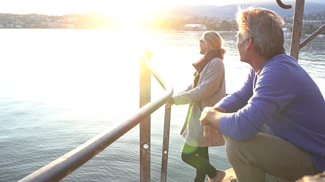 一对夫妇眺望宁静的卢加诺湖，夕阳西下视频素材