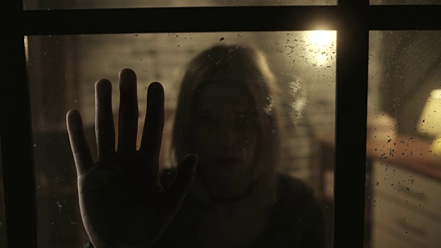 压力大的女人在窗户里手拉手视频素材