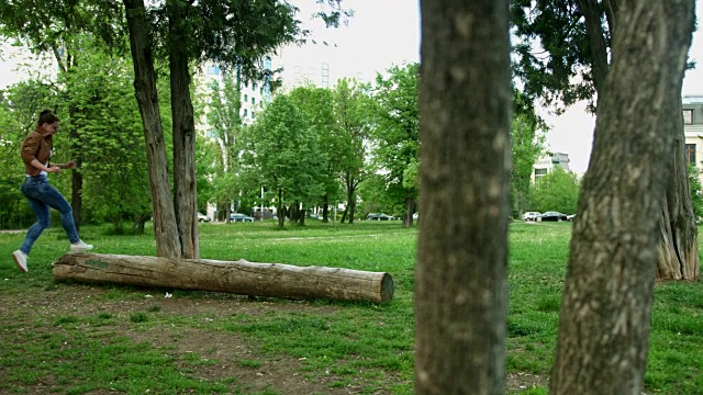广角镜头的一个女孩谁是走和平衡在一个倒下的原木视频下载