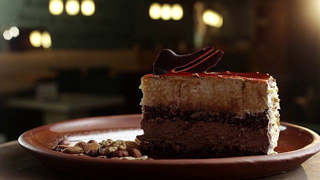 一盘巧克力蛋糕，上面有樱桃，旁边是坚果、杏仁和花生视频素材