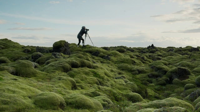 宽摇摄剪影的摄影师在苔藓景观/冰岛视频下载