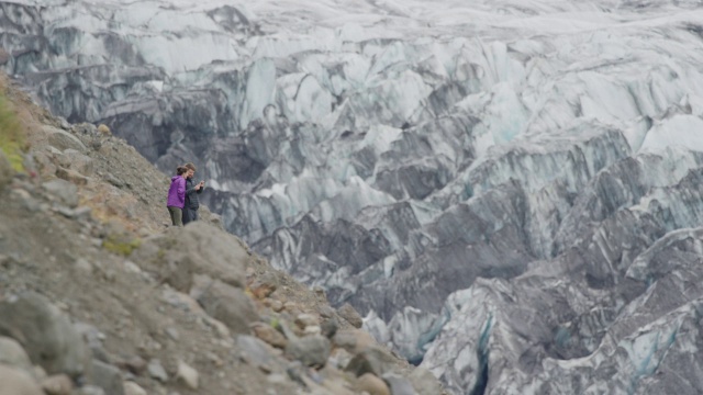 宽镜头的夫妇拍摄冰在山脉/ austurskaftafellssysla，冰岛视频素材