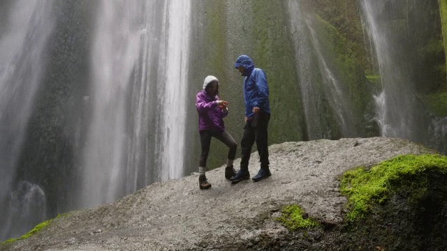 冰岛Rangarvallasysla瀑布附近，一对情侣站在岩石上自拍视频素材