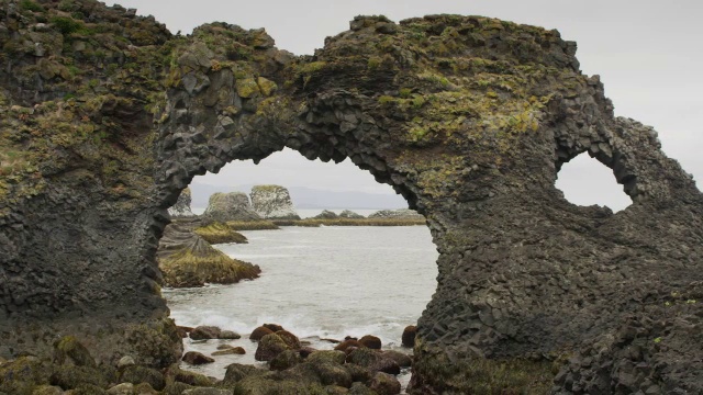 冰岛，Snaefellsnes, Arnarstapi，拱形岩层附近海滩海浪的宽摇摄视频下载