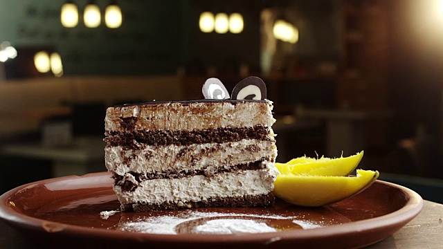 一片巧克力蛋糕，旁边有几片芒果视频素材