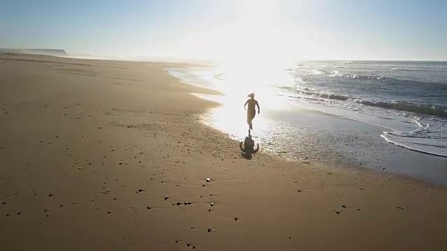 女人沿着海滩慢跑，水花四溅视频下载