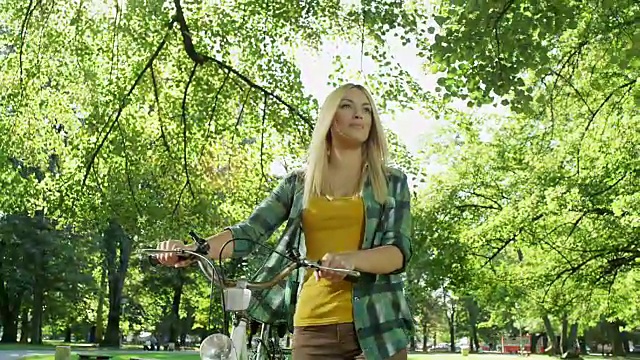 推着自行车穿过公园的漂亮女人视频下载
