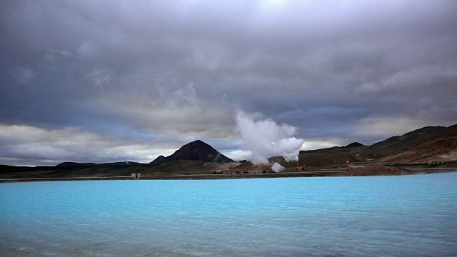 冰岛，一个梦幻般的蓝色湖泊，背景是一个冒着热气的水力发电站视频下载