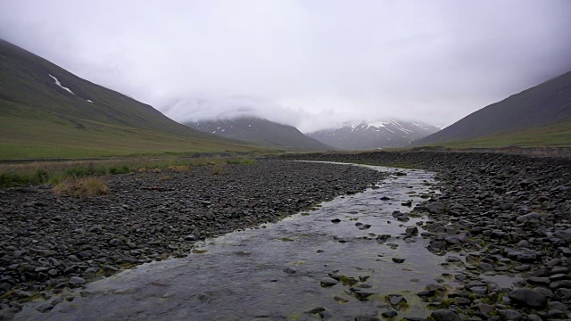 冰岛一条流经寒冷多雾的山脉的河流视频下载