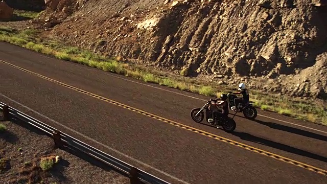 两个男人在沙漠高速公路上骑摩托车，慢镜头视频素材