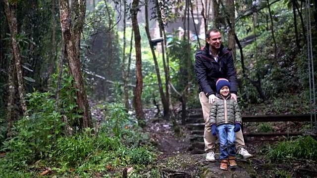 父亲和儿子在树林里小心翼翼地走着视频下载