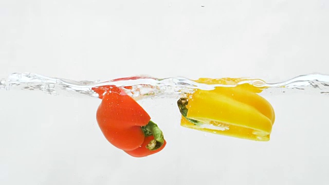 红、黄柿子椒滴入水中的慢动作视频下载