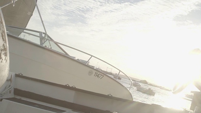 在百慕大岛汉密尔顿港，一艘摩托艇在日落时的波浪中，慢镜头视频下载