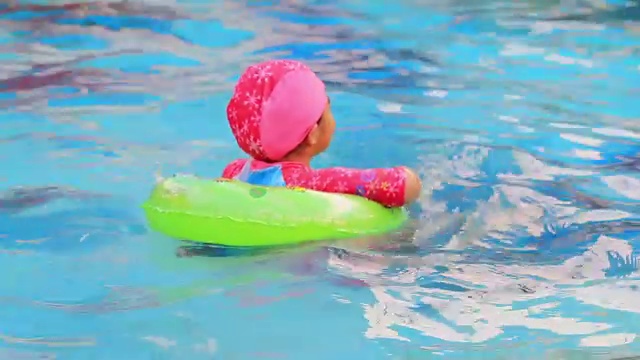 小女孩在游泳池里游泳。视频素材