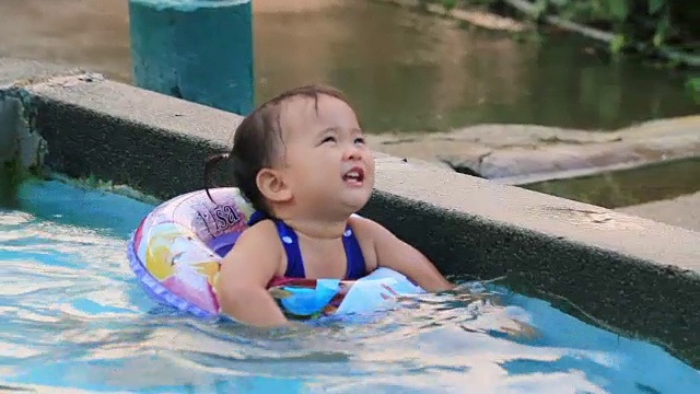 小女孩在游泳池里游泳。视频素材
