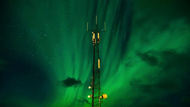 在挪威罗浮敦群岛，云朵和天线的夜空上空，北极光(北极光)的4K延时视频下载