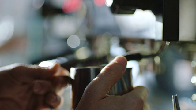 ECU SLO MO:咖啡店的咖啡师用蒸汽泡牛奶，关掉旋钮。视频素材