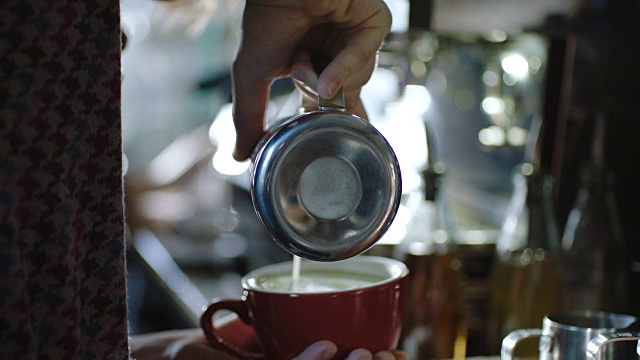 年轻的咖啡师在现代咖啡店制作彩色抹茶拿铁。视频素材
