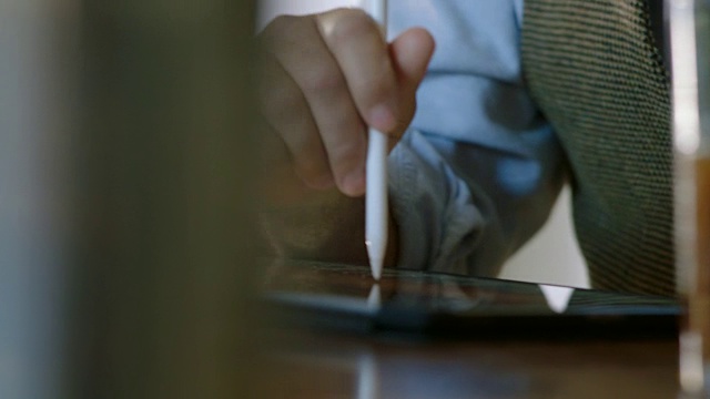 铜。现代咖啡店里，商人用手写笔在平板电脑上做笔记。视频素材