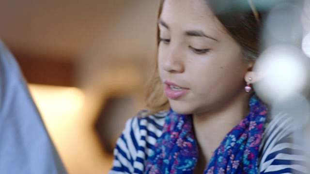 铜。年轻的技术娴熟的女孩教父亲如何使用平板电脑在现代咖啡店。视频素材