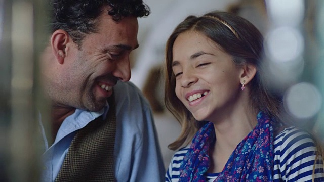 小女孩和她的爸爸在有趣的父女咖啡店约会笑。视频素材