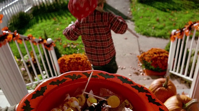 中景男孩在流浪汉服装抓取糖果碗/宾夕法尼亚州视频下载