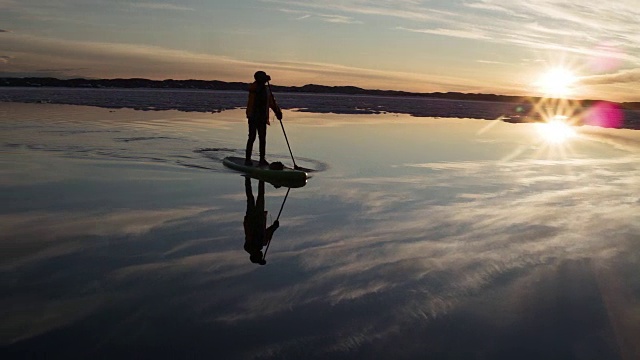 日落时分，加拿大努勒维特，一名男子站在冲浪板上视频素材