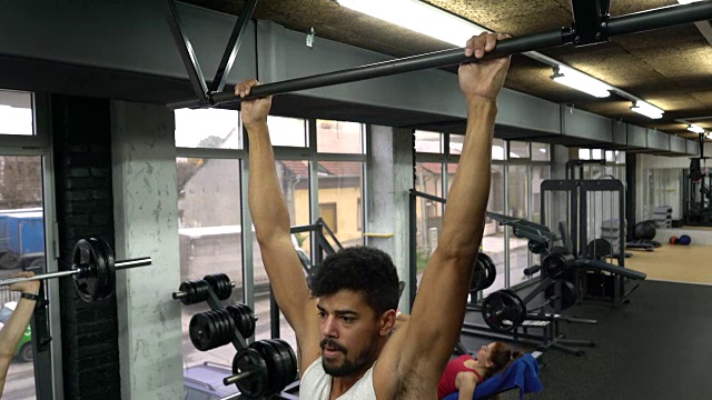 运动型非裔美国人在健身房里做引体向上运动。视频素材