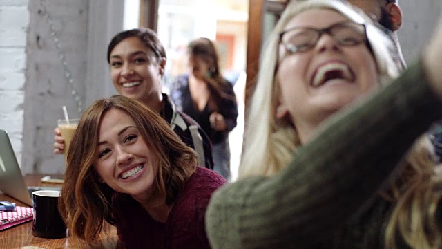 一群朋友在市中心的一家咖啡店用智能手机自拍，开怀大笑。视频素材