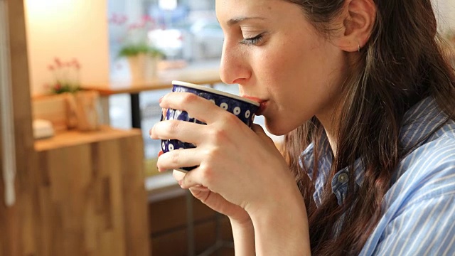 在自助餐厅喝咖啡的微笑女人视频素材