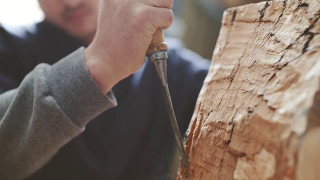 年轻的木匠用凿子雕刻木头视频下载